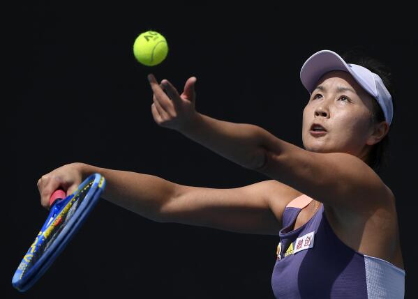 FILE - China's Peng Shuai serves to Japan's Nao Hibino during their first round singles match at the Australian Open tennis championship in Melbourne, Australia, on Jan. 21, 2020. The controversy surrounding Chinese tennis star Peng Shuai’s accusations of sexual assault against a former top politician continues to cast a shadow of the Beijing Winter Olympic Games that officially begin on Friday, Feb. 4. 2022. Peng disappeared from public view in November, 2021, after accusing former Communist Party official Zhang Gaoli of sexual assault. (AP Photo/Andy Brownbill, File)