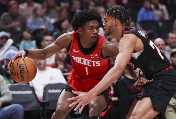 Houston Rockets forward Amen Thompson, left, drives to the basket against Portland Trail Blazers guard Rayan Rupert, right, during the second half of an NBA basketball game Friday, April 12, 2024, in Portland, Ore. (AP Photo/Howard Lao)