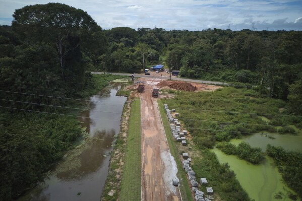 Workers construct an avenue, named Liberdade, or Freedom, ahead of the COP30 U.N. Climate Summit in Belem, Brazil, Tuesday, March 18, 2025. (AP Photo/Jorge Saenz)