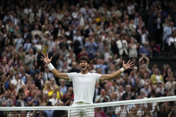 Spain's Carlos Alcaraz celebrates after beating Russia's Daniil Medvedev to win their men's singles semifinal match on day twelve of the Wimbledon tennis championships in London, Friday, July 14, 2023. (AP Photo/Alastair Grant)