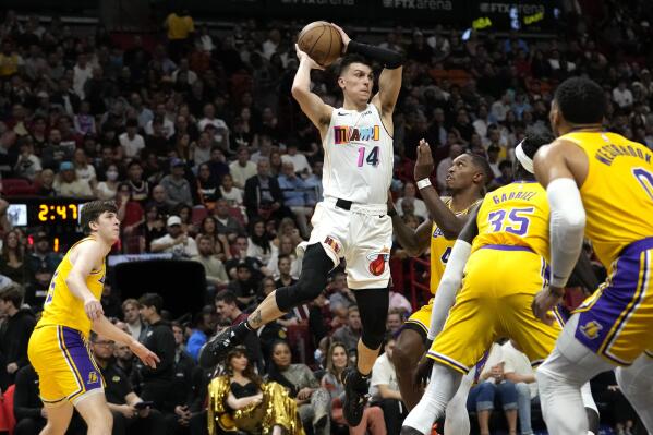 Miami Heat guard Tyler Herro (14) looks to pass as Los Angeles Lakers guard Lonnie Walker IV (4) defends during the first half of an NBA basketball game, Wednesday, Dec. 28, 2022, in Miami. (AP Photo/Lynne Sladky)