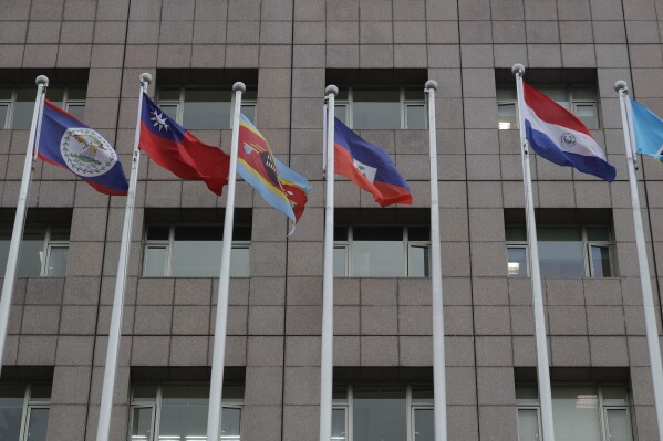 A pole, third from right, where Nauru national flag used to fly is vacant outside the Diplomatic Quarter building in Taipei, Taiwan, Monday, Jan. 15, 2024. The Pacific Island nation of Nauru says it is switching diplomatic recognition from Taiwan to China. The move on Monday leaves Taiwan with 12 diplomatic allies around the world. Taiwan now has official ties with 11 countries and the Vatican. (AP Photo/Chiang Ying-ying)