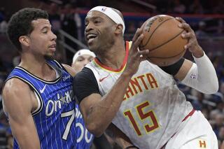 FILE - Atlanta Hawks forward Vince Carter (15) drives to the basket against Orlando Magic guard Michael Carter-Williams (7) during the first half of an NBA basketball game in Orlando, Fla., Friday, April 5, 2019. Police say nearly $100,000 in cash was taken in a weekend burglary at the Atlanta home of former NBA player Vince Carter. Police said in an incident report released Wednesday, June 22, 2022 that two guns and more than $16,000 was recovered outside the home after Sunday's burglary. (AP Photo/Phelan M. Ebenhack, File)