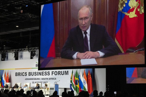 Russian President Vladimir Putin addresses leaders from the BRICS group of emerging economies at the start of a three-day summit in Johannesburg, South Africa , Tuesday, Aug. 22, 2023. Putin appeared on a video link after his travel to South Africa was complicated by an International Criminal Court arrest warrant against him over the war in Ukraine. (AP Photo/Jerome Delay)