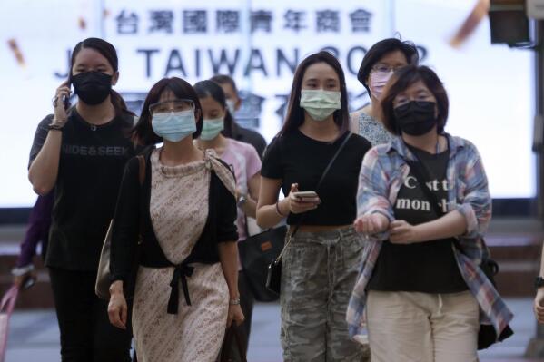 In this July 8, 2021, file photo, people wear face masks to protect against the spread of the coronavirus after the COVID-19 alert raise to level 3 in Taipei, Taiwan. Two Taiwanese high-tech companies announced a donation Monday of 10 million doses of the anti-coronavirus vaccine developed by Germany’s BioNTech to the island’s government. (AP Photo/Chiang Ying-ying, File)