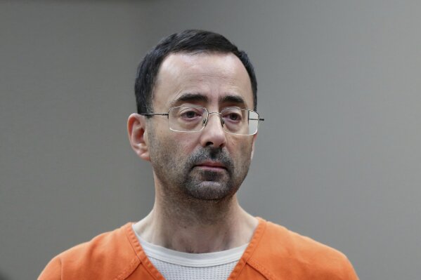FILE - In this Nov. 22, 2017, file photo, Larry Nassar, 54, appears in court for a plea hearing in Lansing, Mich. The Education Department is fining Michigan State University $4.5 million for failing to respond to sexual assault complaints against Dr. Larry Nassar.  (AP Photo/Paul Sancya, File)