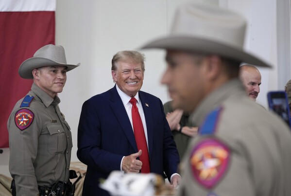 Republican presidential candidate and former President Donald Trump helps serve food to Texas National Guard soldiers, troopers and others who will be stationed at the border over Thanksgiving, Sunday, Nov. 19, 2023, in Edinburg, Texas. (AP Photo/Eric Gay)