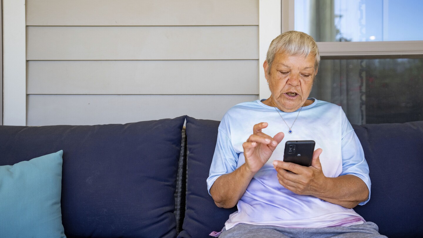 Sheri Wilkins talks about her experience using the DailyPay app outside of the clubhouse at her apartment complex in College Station, Texas on Tuesday