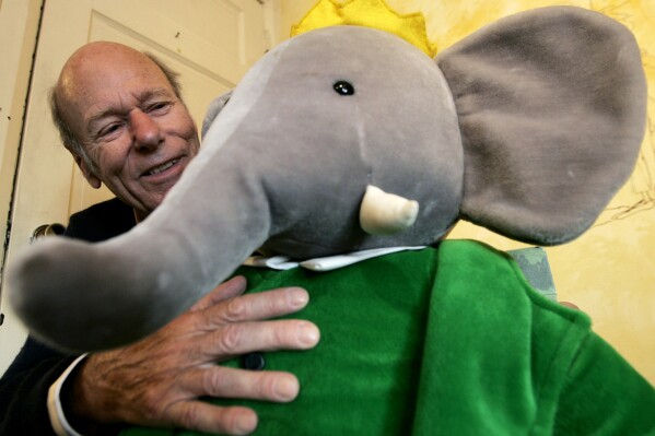 FILE - Babar author Laurent de Brunhoff poses for a photograph with Babar while celebrating 75 years of the book on Friday, April 21, 2006 at Mabel's Fables in Toronto, Ontario, Canada. De Brunhoff, a Paris native who moved to the U.S. in the 1980s, died Friday, March 22, 2024 at his home in Key West, Fla., according to The New York Times. (Nathan Denette /The Canadian Press via AP)