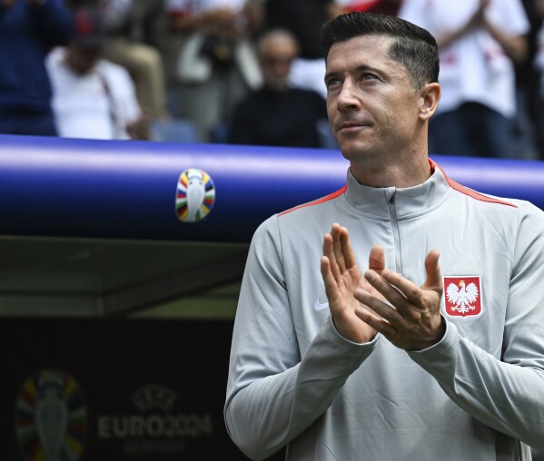 Poland's Robert Lewandowski applauds prior to a Group D match between Poland and the Netherlands at the Euro 2024 soccer tournament in Hamburg, Germany, Sunday, June 16, 2024. (Sina Schuldt/dpa via AP)