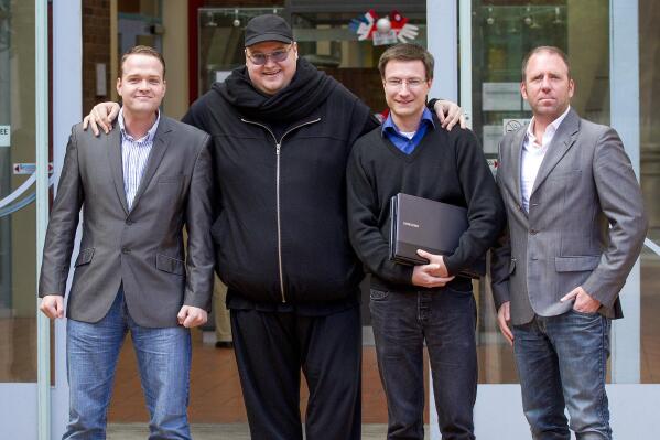 FILE - Megaupload founder Kim Dotcom, second left, stands with Bram van der Kolk, left, Mathias Ortmann and Finn Batato, right, outside the High Court in Auckland, New Zealand, Aug. 9, 2012. Ortmann and van der Kolk, charged by U.S. prosecutors for their involvement in the once wildly popular file-sharing website Megaupload, have pleaded guilty, Wednesday, June 22, 2022, to charges in New Zealand as part of a deal to avoid extradition to the U.S. The U.S. is still trying to extradite founder Kim Dotcom. (Sarah Ivey/New Zealand Herald via AP)