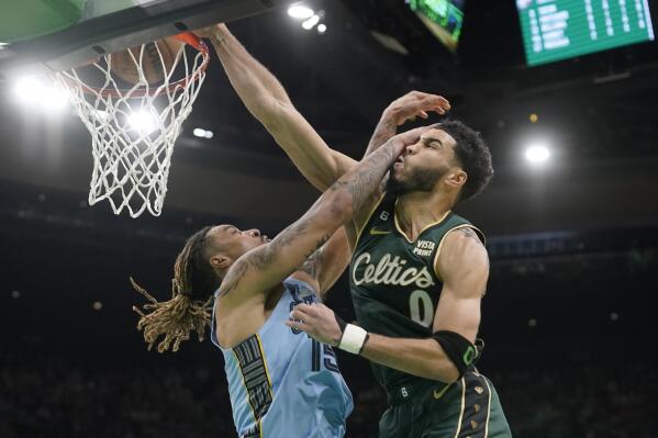 Boston Celtics forward Jayson Tatum (0) drives toward the basket past Memphis Grizzlies forward Brandon Clarke, left, in the first half of an NBA basketball game, Sunday, Feb. 12, 2023, in Boston. (AP Photo/Steven Senne)
