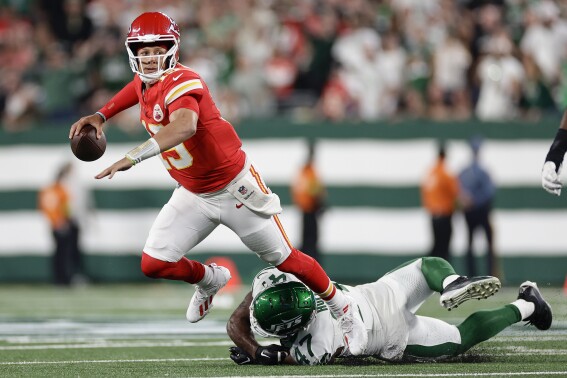 Kansas City Chiefs quarterback Patrick Mahomes (15) is tripped up by New York Jets linebacker Bryce Huff (47) as he throws during the second quarter of an NFL football game, Sunday, Oct. 1, 2023, in East Rutherford, N.J. (AP Photo/Adam Hunger)