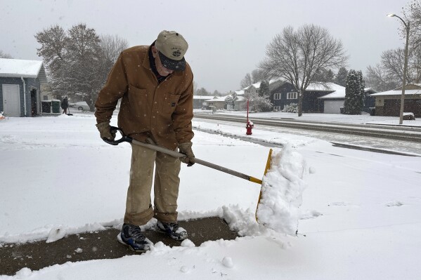 Steve Geisinger shovels snow shovels snow, Thursday, Oct. 26, 2023, in Bismarck, N.D. The snowstorm moving east from the northern Rockies dumped nearly a foot of snow in places in northwestern North Dakota after moving into the state on Wednesday, with more snow expected later on Thursday for southwestern and central North Dakota. As much as 11 inches of snow fell near Stanley in northwestern North Dakota, according to the National Weather Service. (AP Photo/Jack Dura)