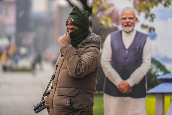 An Indian policeman stands guard near a cutout portrait of Indian Prime Minister Narendra Modi displayed at the main market in Srinagar, Indian controlled Kashmir, Monday, Dec. 11, 2023. India’s top court on Monday upheld a 2019 decision by Prime Minister Narendra Modi’s government to strip disputed Jammu and Kashmir’s special status as a semi-autonomous region with a separate constitution and inherited protections on land and jobs. (AP Photo/Mukhtar Khan)