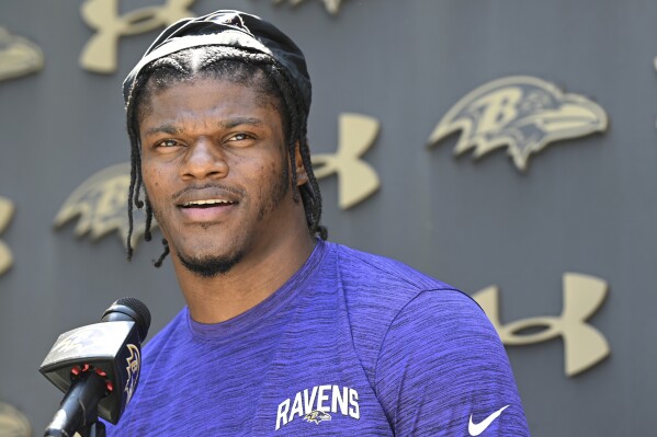 FILE - Baltimore Ravens quarterback Lamar Jackson answers questions from the media before a mandatory NFL football mini camp Wednesday, June 14, 2023, in Owings Mills, Md. Lamar Jackson is back with the Ravens on a long-term contract, so the uncertainty that hovered over the team entering camp last year is gone. (AP Photo/Gail Burton, File)