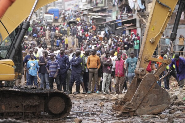 Residents watch as excavators and bulldozers bring down their homes in the Mathare area of Nairobi, Wednesday, May 8, 2024. The Kenyan government ordered the evacuation of people from flood-prone areas, resulting in the demolition of houses and the loss of at least one life in the melee caused by the forced evictions. (AP Photo/Brian Inganga)