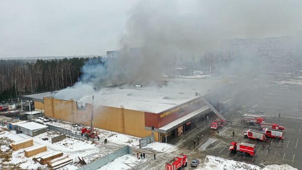 In this handout photo released by Russian Emergency Ministry Press Service, smoke rises from the mall in Balashikha, just outside Moscow, Russia, Monday, Dec. 12, 2022. A massive fire has gutted a shopping mall on Moscow's eastern outskirts, the second such blaze in four days. Monday's blaze at the mall in Balashikha that trades in construction items and decorative materials first erupted at a storage area and later spread to part of the building. The fire teams managed to localize it at the area of about 3,000 square meters (about 32,300 square feet) and prevent it from engulfing the entire mall. (Russian Emergency Ministry Press Service via AP)