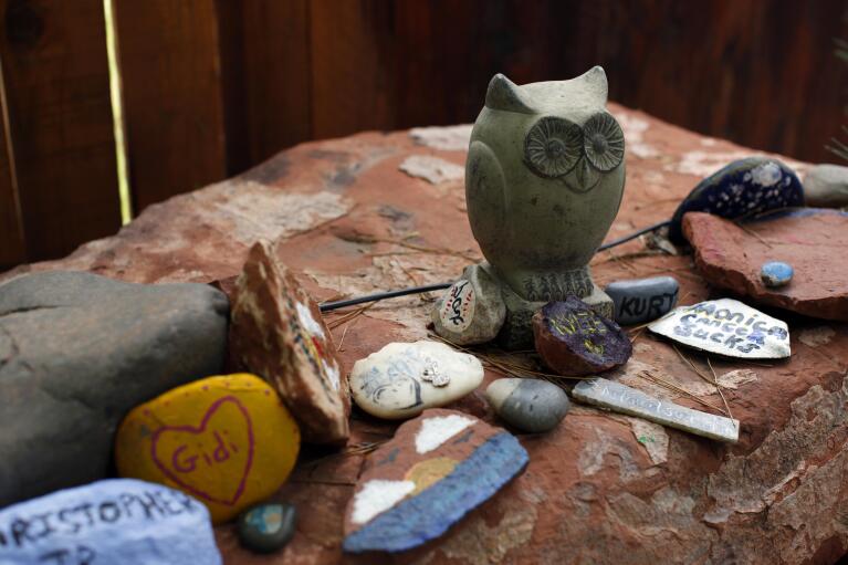 Painted rocks and objects to remember lost ones are laid out at a quiet space in the Selah Carefarm in Cornville, Ariz., Oct. 4, 2022. (AP Photo/Dario Lopez-Mills)
