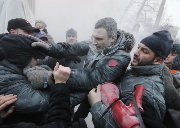 FILE - In this file photo taken on Jan. 19, 2014, opposition leader and former WBC heavyweight boxing champion Vitali Klitschko, center, is attacked and sprayed with a fire extinguisher as he tries to stop clashes between police and protesters in central Kyiv, Ukraine. On Nov. 21, 2023, Ukraine marks the 10th anniversary of the uprising that eventually led to the ouster of the country’s Moscow-friendly president. (AP Photo/Efrem Lukatsky, file)