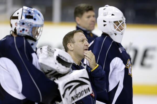 FILE - Nashville Predators goaltending coach Mitch Korn, center, watches players during NHL hockey training camp on Thursday, Sept. 12, 2013, in Nashville, Tenn. Longtime goalie guru Mitch Korn is back with the Nashville Predators to oversee their operation at the most important position in hockey. The team hired Korn as director of goaltending a decade after his first 15-year stint with the Predators came to an end. (AP Photo/Mark Humphrey, File)