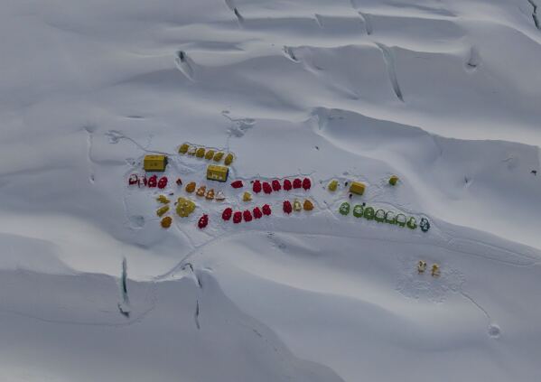 AP PHOTOS: Loads scale Mount Everest in a weather-hit hiking season