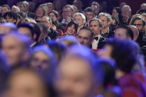 Anne Hathaway, center, watches the opening ceremony at the International Film Festival Berlin 'Berlinale', in Berlin, Germany, Thursday, Feb. 16, 2023. (AP Photo/Markus Schreiber)