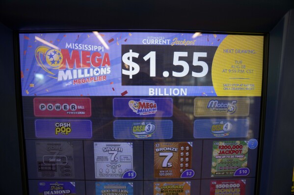 An electronic sign on a scratch off dispenser, beckons players Monday, Aug. 7, 2023, to cast their lot at winning all or part of Tuesday's Mega Millions drawing of $1.55 billion, at this Jackson, Miss., convenience store. There now have been 31 straight drawings without a big jackpot winner. (AP Photo/Rogelio V. Solis)