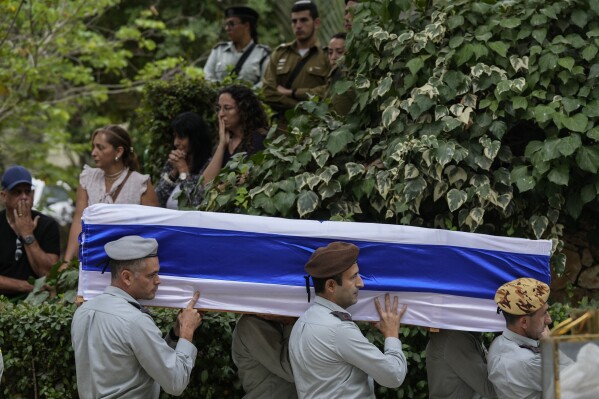 FILE - Israeli soldiers carry the flag-covered coffin of Col. Roi Levy during his funeral at the Mount Herzl cemetery in Jerusalem on Monday, Oct. 9, 2023. Col. Levy was killed after Hamas militants stormed from the blockaded Gaza Strip into nearby Israeli towns. (AP Photo/Maya Alleruzzo, File)