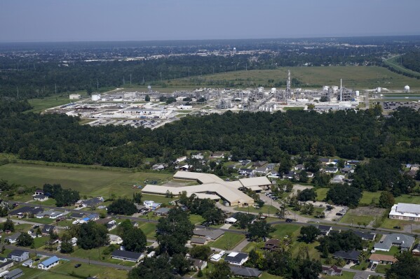 FILE - The Fifth Ward Elementary School and residential neighborhoods sit near the Denka Performance Elastomer Plant, back, in Reserve, La., Sept. 23, 2022. The EPA sued Denka Performance Elastomer LLC, arguing that its petrochemical operations in southern Louisiana posed an unacceptable cancer risk to the mostly-Black community nearby. The EPA has demanded that the company reduce toxic emissions from its plant that makes synthetic rubber. (AP Photo/Gerald Herbert, File)