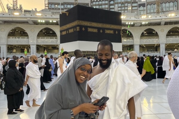 Somalian pilgrims prepare for a selfie in front of the Kaaba, the cubic building at the Grand Mosque, during the annual hajj pilgrimage in Mecca, Saudi Arabia, Monday, June 26, 2023, before heading to Mina in preparation for the Hajj, the fifth pillar of Islam and one of the largest religious gatherings in the world. (AP Photo/Amr Nabil)