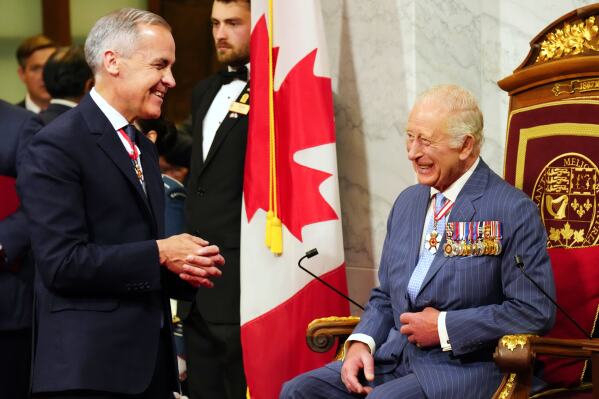 Canadian Prime Minister Mark Carney, left, speaks with King Charles ahead of the King delivering the speech from the throne in the Senate in Ottawa on Tuesday, May 27, 2025. (Chris Young/The Canadian Press via AP)