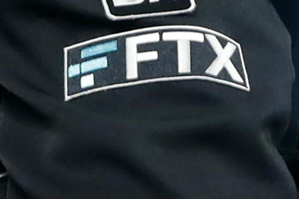 File - The FTX logo appears on home plate umpire Jansen Visconti's jacket at a baseball game with the Minnesota Twins on Tuesday, Sept. 27, 2022, in Minneapolis. The new CEO of the collapse cryptocurrency trading firm FTX, who oversaw Enron’s bankruptcy, said, Thursday, Nov. 17,  he has never seen such a “complete failure” of corporate control. John Ray III, in a filing with the U.S. bankruptcy court for the district of Delaware, said there was a “complete absence of trustworthy financial information.”  (AP Photo/Bruce Kluckhohn, File)