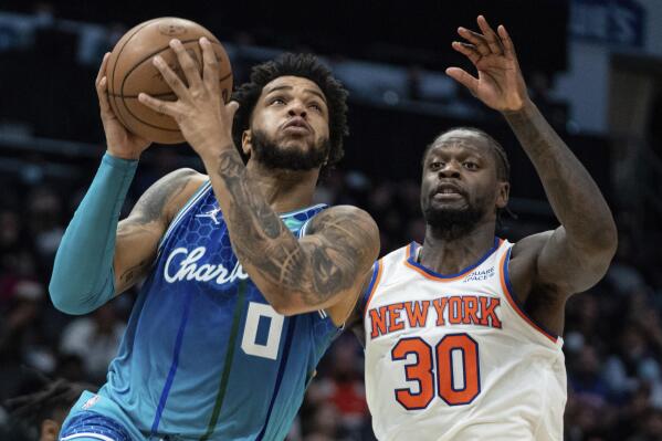 Charlotte Hornets forward Miles Bridges (0) drives to the basket past New York Knicks forward Julius Randle (30) during the first half of an NBA basketball game in Charlotte, N.C., Friday, Nov. 12, 2021. (AP Photo/Jacob Kupferman)
