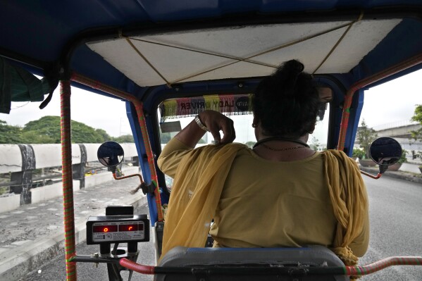 Preethi, a 38-year-old transgender woman who uses only her first name, rides her electric auto rickshaw looking for passengers in Bengaluru, India, Monday, July 10, 2023. (AP Photo/Aijaz Rahi)