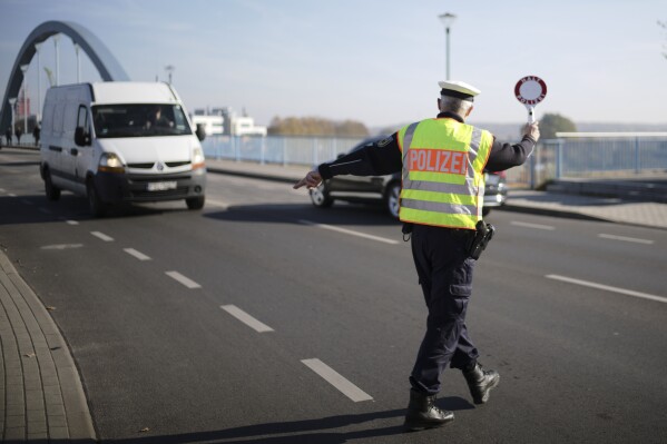 FILE - A officer of German Federal Police stops a van to search for immigrants at the border crossing from Poland into Germany in Frankfurt an der Oder, Germany, Oct. 28, 2021. Germany will increase its police patrols along 