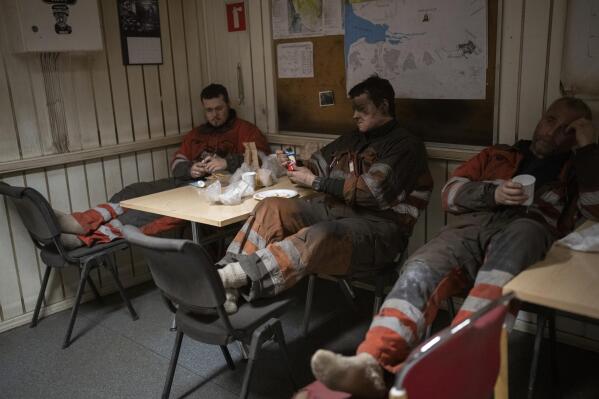 Coal miners rest during a shift in the break room of the Gruve 7 coal mine in Adventdalen, Norway, Monday, Jan. 9, 2023. (AP Photo/Daniel Cole)