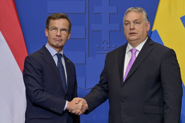 Sweden's Prime Minister Ulf Kristersson, left, shakes hands with his Hungarian counterpart Viktor Orban at the Carmelite Monastery in Budapest, Hungary, Friday, Feb 23, 2024. Nearly two years after Sweden formally applied to join NATO, its membership now hinges on convincing one country - Viktor Orban's Hungary - to formally ratify its bid to join the military alliance. (AP Photo/Denes Erdos)