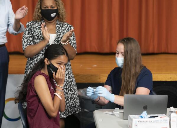 Ariel Quero, 16, left, a student at Lehman High School, reacts after getting the Pfizer COVID-19 vaccine from Katrina Taormina, right, July 27, 2021, in New York. The U.S. is expanding COVID-19 boosters, ruling that 16- and 17-year-olds can get a third dose of Pfizer’s vaccine. The U.S. and many other nations already were urging adults to get booster shots to pump up immunity that can wane months after vaccination, calls that intensified with the discovery of the worrisome new omicron variant. On Thursday, Dec. 9, 2021 the FDA gave emergency authorization for 16- and 17-year-olds to get a third dose of the vaccine made by Pfizer and its partner BioNTech -- if it’s been six months since their last shot. (AP Photo/Mark Lennihan, file)
