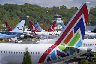 FILE — In this April 26, 2021, file photo Boeing 737 Max airplanes sit parked in a storage lot, near Boeing Field in Seattle. The Boeing Co. told employees, Tuesday, Oct. 12, 2021, that they must be vaccinated against COVID-19 or possibly be fired. The Seattle Times reports the deadline for workers at the aerospace giant is Dec. 8. (AP Photo/Ted S. Warren, File)