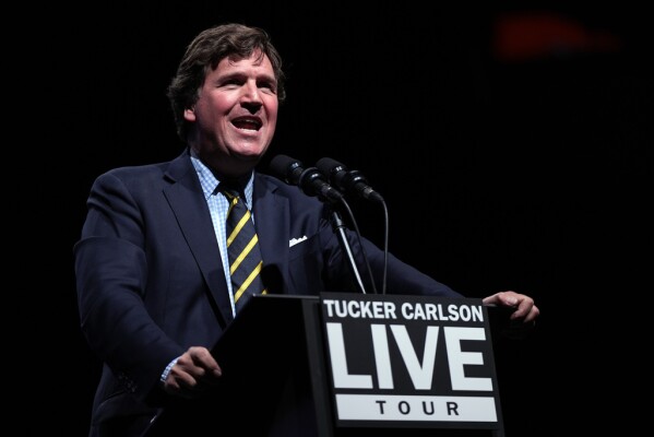 Tucker Carlson speaks before talking with Republican presidential nominee former President Donald Trump at a Tucker Carlson Live Tour show at Desert Diamond Arena, Thursday, Oct. 31, 2024, in Glendale, Ariz. (AP Photo/Julia Demaree Nikhinson)