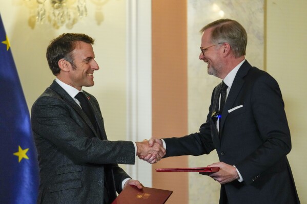 Czech Republic's Prime Minister Petr Fiala, right, shakes hands with French President Emmanuel Macron after signing an action plan in Prague, Czech Republic, Tuesday, March 5, 2024. Macron is on a one-day official visit to Czech Republic. (AP Photo/Petr David Josek)