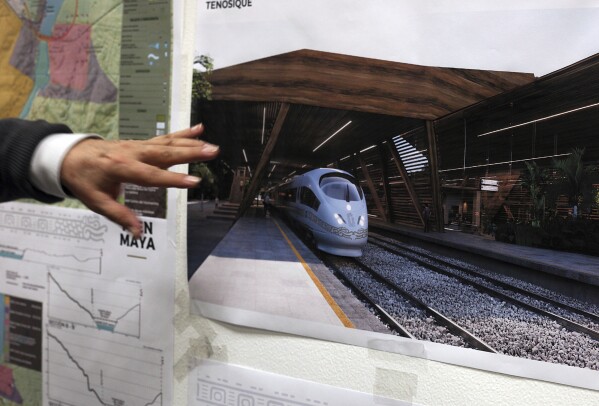 FILE - Rogelio Jiménez Pons, director of Fonatur, points to photos of a planned train through the Yucatan Peninsula, during an interview in Mexico City, March 18, 2019. Mexico’s President Andrés Manuel López Obrador is in a rush to finish the big legislative and building projects he promised before his term ends in September 2024, chief among the projects are railway lines, like the Mayan Train. (AP Photo/Marco Ugarte, File)