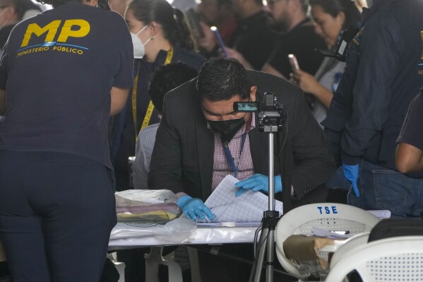 Agents from the Attorney General's office check June 25th general elections ballots during a raid at a temporary facility of the Supreme Electoral Tribunal, in Guatemala City, Tuesday, Sept. 12, 2023. (AP Photo/Moises Castillo)