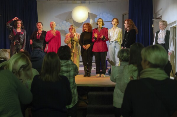 Spectators applaud to actresses playing male roles on the stage of the Chernihiv Regional Youth Theater, which reinvented itself with an all-female cast, with most male actors at war, in Chernihiv, Ukraine, Sunday, Feb. 16, 2025. (AP Photo/Efrem Lukatsky)