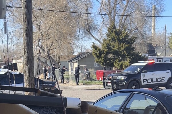 In this image taken from video, police are seen shortly before opening fire on a teen on the other other side of a fence Saturday, April 5, 2025, in Pocatello, Idaho. (Brad Andres via AP, File)