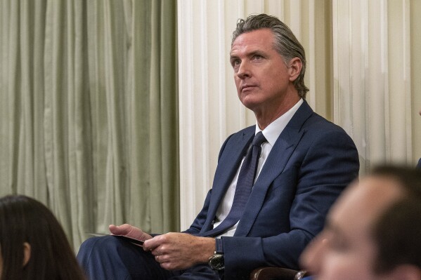 FILE – California Gov. Gavin Newsom sits in the state Assembly at the state Capitol, June 30, 2023, in Sacramento, Calif. In an interview with The Associated Press, Newsom said the prospect of multi-billion dollar budget deficits over the next few years does not change his agenda for his second term in office. Newsom said he will focus on implementing the programs he launched in his first term, including free kindergarten for all 4-year-olds and free health care for low-income residents regardless of their immigration status. (AP Photo/Rich Pedroncelli,File)
