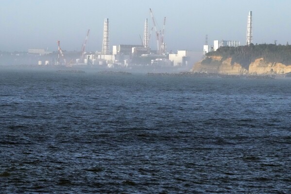 FILE - The Fukushima Daiichi nuclear power plant, damaged by a massive March 11, 2011, earthquake and tsunami, is seen from the nearby Ukedo fishing port in Namie town, northeastern Japan, Thursday, Aug. 24, 2023. For the wrecked Fukushima Daiichi nuclear plant, managing the ever-growing radioactive water held in more than 1,000 tanks has been a safety risk and a burden since the meltdown in March 2011. The start of treated wastewater release Thursday marked a milestone for the decommissioning, which is expected to take decades. (AP Photo/Eugene Hoshiko, File)