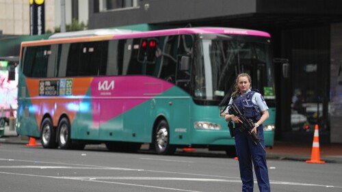 Armed New Zealand police officers stand outside a hotel housing a FIFA Women's World Cup team in the central business district after a shooting in Auckland, New Zealand, Thursday, July 20, 2023. New Zealand police are responding to reports that a gunman fired shots into a building in downtown Auckland.  (AP Photo/Abbie Parr)