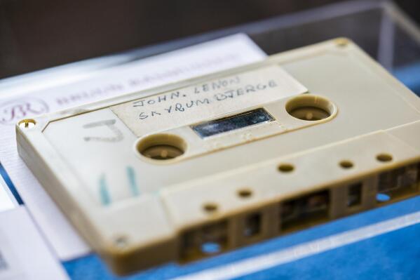 FILE - In this Friday, Sept. 24, 2021 file photo, a view of a cassette with the recording of four Danish schoolboys' interviews with John Lennon and Yoko Ono during the famous couple's winter stay in Thy, in Jutland, Denmark, in 1970, on display at Bruun Rasmussen Auction House in Copenhagen.  A cassette with a 33-minute audio recording of John Lennon, who was interviewed by four Danish teenagers for their school paper, and an apparently unpublished song by the late Beatle, has fetched 370,000 kroner ($58,240) at an auction Tuesday, Sept. 28, 2021. (Ida Marie Odgaard/Ritzau Scanpix via AP, File)